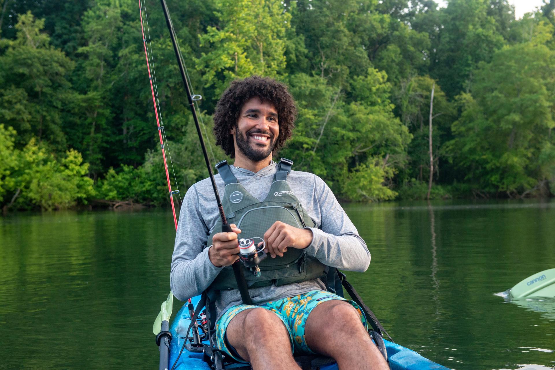 Guy smiling fishing with GX2 Spinning Rod