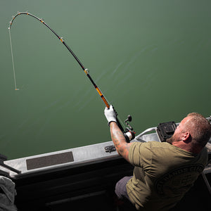 Overhead view of an angler using an Ugly Stik catfish rod from a boat.