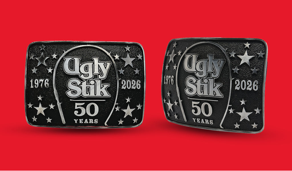Two Ugly Stik belt buckles with 50th Anniversary logo on a red background
