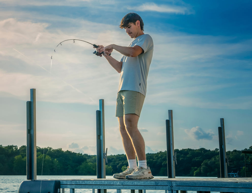 Man fishing on a dock with a Dock Runner with a scenic background 