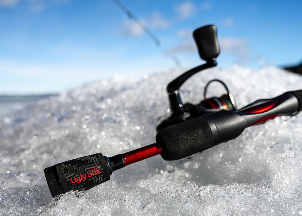 Fishing rod with Ugly Stik+ holder on a snowy surface with a blurred background